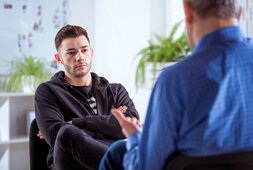 Junger Mann im Gespräch mit seinem Therapeuten | © Iza Habur - izusek - Getty Images